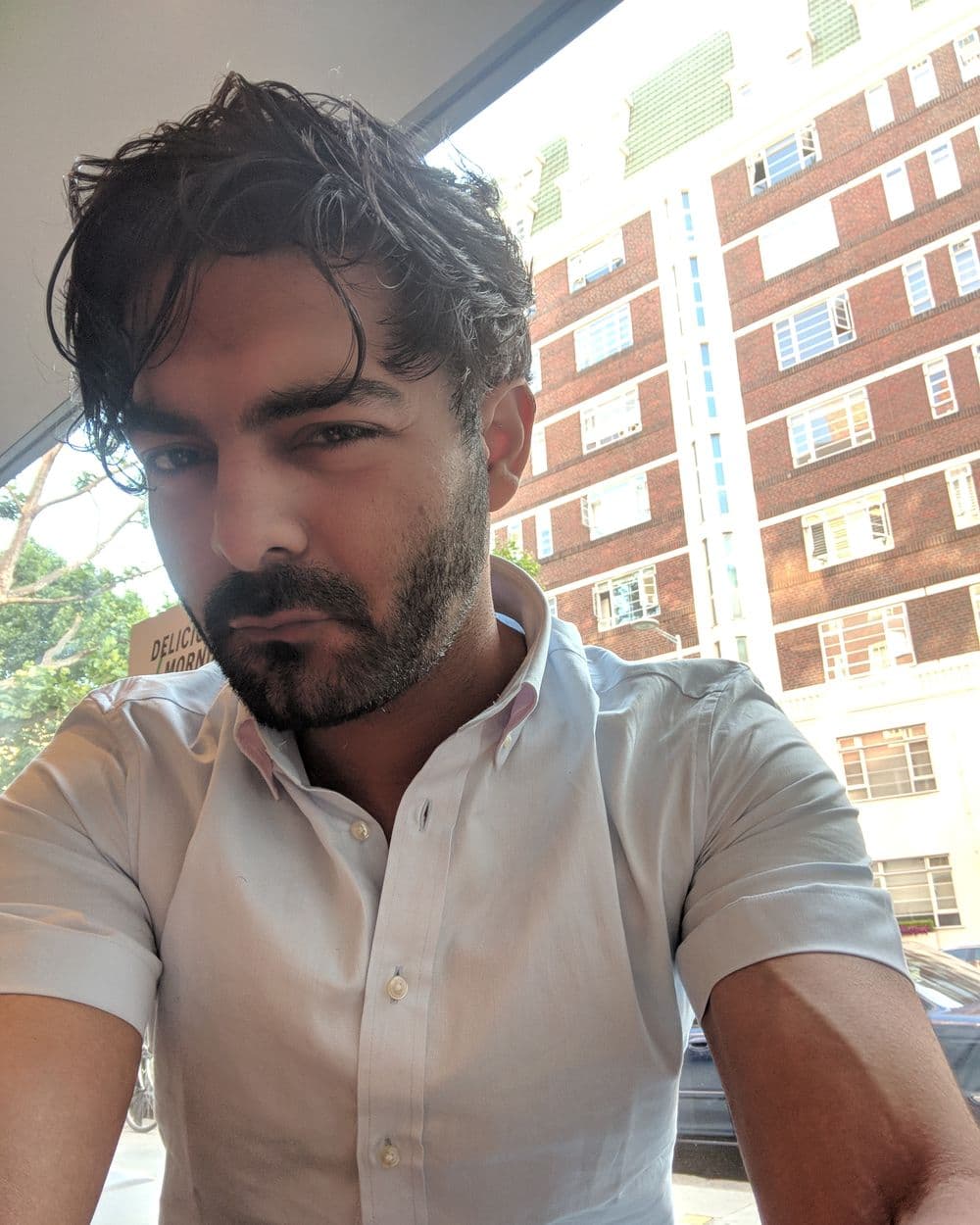Sahil in a white shirt on a London street