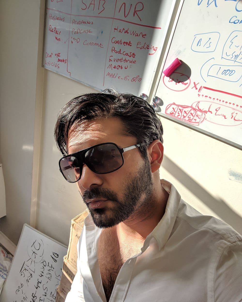 Sahil in sunglasses in front of a whiteboard of plans